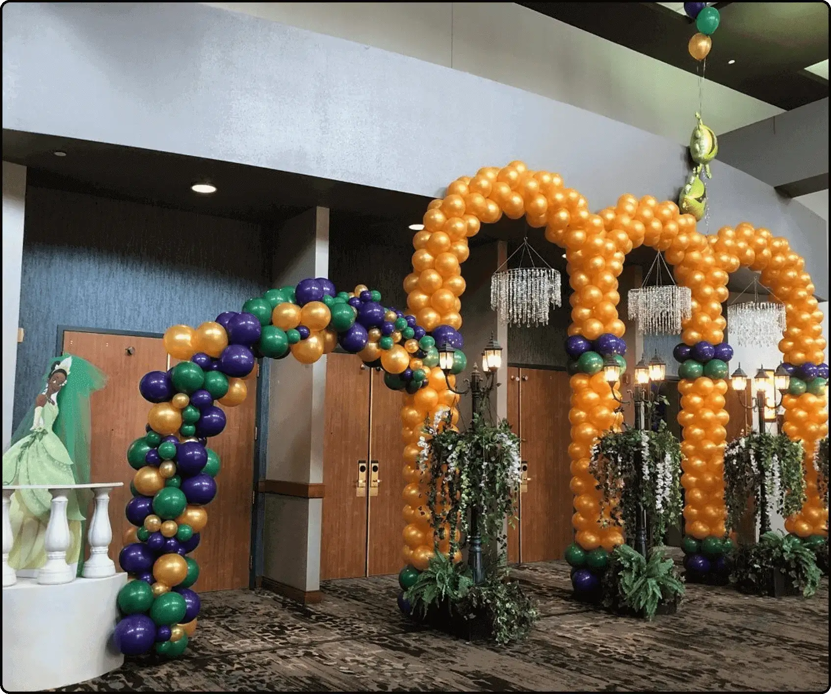 Colorful balloon arches at an indoor event.